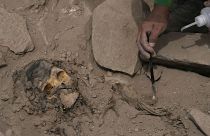 An archaeologist excavates a pre-Hispanic mummy that was discovered next to a training field in the El Rimac neighborhood of Lima, Peru, Thursday, June 15, 2023.
