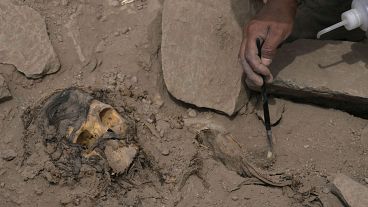 An archaeologist excavates a pre-Hispanic mummy that was discovered next to a training field in the El Rimac neighborhood of Lima, Peru, Thursday, June 15, 2023.