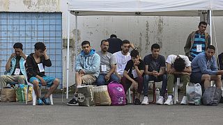 Διασωθέντες του ναυαγίου ανοιχτά της Πύλου περιμένουν να επιβιβαστούν σε λεωφορεία και να μεταβούν στο κέντρο υποδοχής μεταναστών στην Μαλακάσα