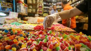 بائع يصفف الحلويات في متجره في سوق الحميدية في العاصمة السورية دمشق.