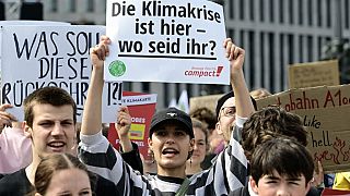 Protester in Berlin holds up sign saying "The climate crisis is here - where are you?"