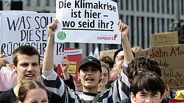 Protester in Berlin holds up sign saying "The climate crisis is here - where are you?"