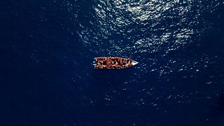Migrants from Eritrea, Libya and Sudan sail a wooden boat in the Mediterranean before being assisted by aid workers of the Spanish NGO Open Arms.