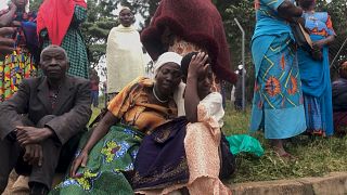 Familiares das vítimas do massacre comovidos durante o enterro, Uganda