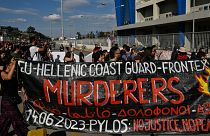 "Guarda Costeira grega - Frontex: assassinos", lê-se neste cartaz de protesto no Porto do Pireu