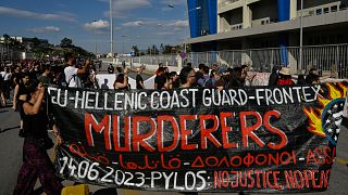 "Guarda Costeira grega - Frontex: assassinos", lê-se neste cartaz de protesto no Porto do Pireu