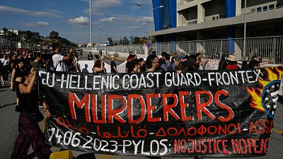 "Guarda Costeira grega - Frontex: assassinos", lê-se neste cartaz de protesto no Porto do Pireu