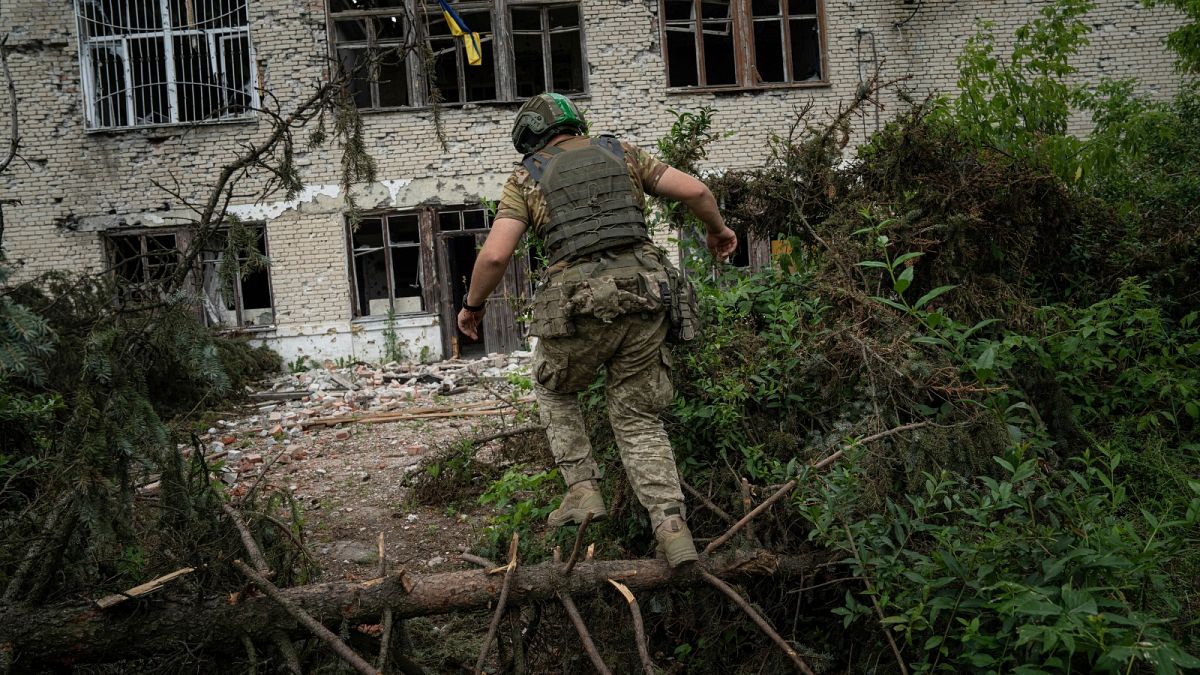A Ukrainian serviceman of the 68th Oleksa Dovbush hunting brigade runs to his position in the recently retaken village of Blahodatne,