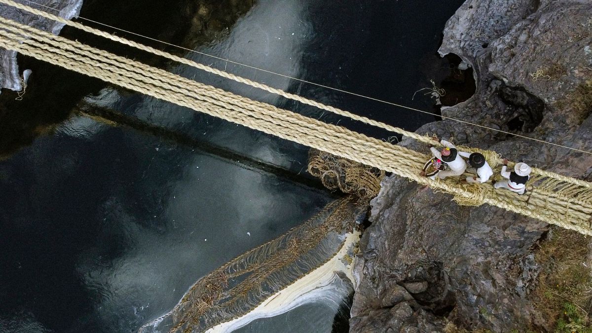 Aerial view showing people from different communities participating in the annual renovation of the Q'eswachaka rope bridge
