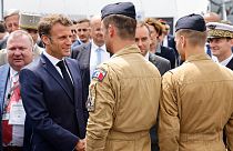 France's President Emmanuel Macron (L) greets Rafale pilots as he visits in the International Paris Air Show at the Paris–Le Bourget Airport on June 19, 2023.