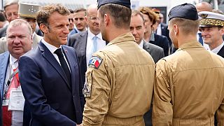 France's President Emmanuel Macron (L) greets Rafale pilots as he visits in the International Paris Air Show at the Paris–Le Bourget Airport on June 19, 2023.