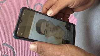محمد صالح، والد يحيى صالح البالغ من العمر 18 عاما، يحمل هاتفا به صورة لابنه في منزله بإبراش، مصر، الأحد 18 يونيو 2023.