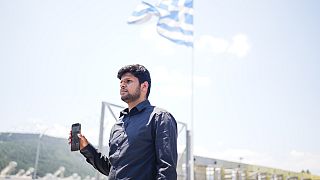 Zohaib Shamraiz holds up a photograph of his uncle missing uncle, Nadeem Muhamm, outside a migrant camp in Malakasa north of Athens, on Monday, June 19, 2023.