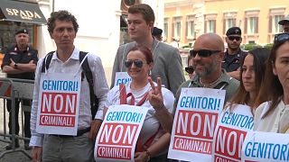 "Pais, não criminosos", lê-se em cartazes de protesto contra a criminalização da maternidade de substituição, Roma, Itália