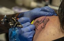 Henk Schiffmacher tatua as linhas de um elefante nas costas de uma cliente, em Amesterdão.