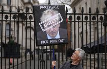 متظاهر يحمل لافتة تحمل عبارات مناهضة لرئيس الوزراء البريطاني بوريس جونسون أمام مدخل داونينغ ستريت في لندن. 2022/04/13