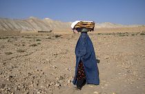 Una mujer afgana, camino de su casa, portando en la cabeza el pan que compró en el mercado de Bamiyán