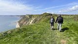 Turisti camminano lungo una zona costiera delle isole britanniche