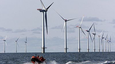 A speed boat passes by offshore windmills in the North Sea offshore from the village of Blavandshuk near Esbjerg, Denmark in this file photo