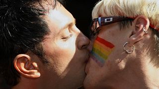 Csókolózó férfiak egy Pride-felvonuláson Észtország fővárosában, Tallinnban