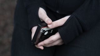 Amelia, 16, holds her phone as she sits for a portrait in a park near her home in Illinois, on 24 March 2023