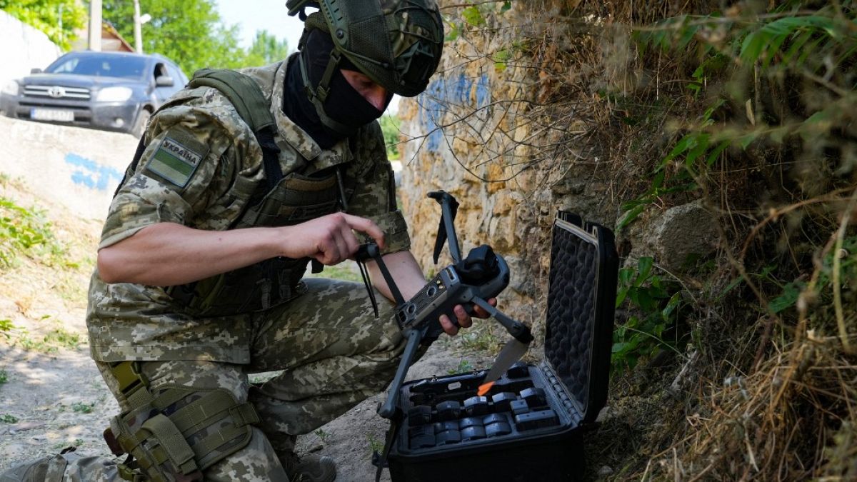 Un soldat ukrainien programme un drone pour détecter les mines dans la région du barrage de Kakhovka.