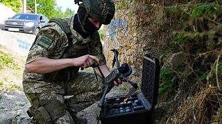 Ein ukrainischer Soldat programmiert eine Drohne, um Minen in der Region um den Kachowka-Damm aufzuspüren.