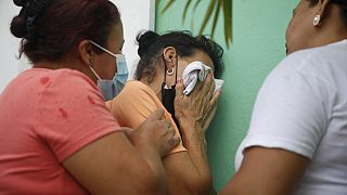 Des parents de détenues attendent  devant l'entrée de la prison pour femmes de Tamara, dans la banlieue de Tegucigalpa, au Honduras (20/06/23)