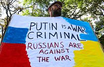 Un manifestant tient une pancarte lors d'une petite manifestation contre l'invasion de l'Ukraine par la Russie, devant l'ambassade russe à Nairobi au Kenya, samedi 26 février