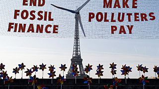 Una pancarta frente a la Torre Eiffel la convierte en un molino de viento este lunes 21 de junio en París.