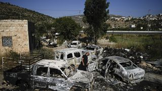 فلسطيني يعاين سيارات أحرقها مستوطنون في بلدة اللبان في الضفة الغربية المحتلة 21/06/2023
