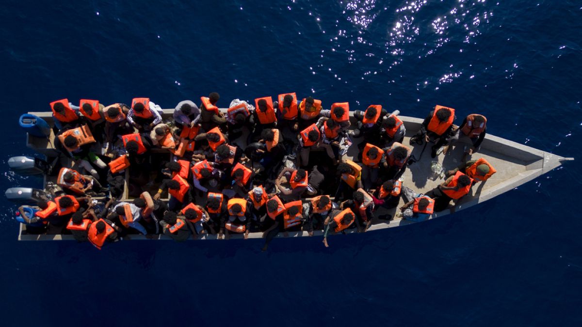 Migrantes navegan en una barca de madera en el mar Mediterráneo, a unas 30 millas al norte de Libia, el 17 de junio de 2023.