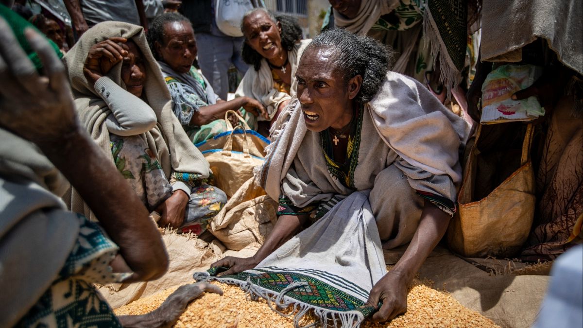 سيدة إثيوبية تتجادل مع آخرين حول تخصيص البازلاء الصفراء بعد توزيعها من قبل جمعية الإغاثة ببلدة أغولا، في منطقة تيغراي بشمال إثيوبيا
