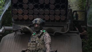 جندي أوكراني يقف بجانب راجمة صواريخ على خط المواجهة بالقرب من باخموت في منطقة دونيتسك - أوكرانيا. 2023/06/21