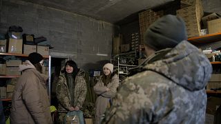 Kseniia Drahaniuk, a Zemljacski civil szervezet tagja (balra) katonákkal beszélget Kijevben