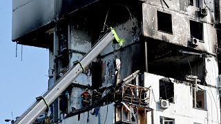 أفراد خدمة الإنقاذ في حالات الطوارئ يقفون داخل مبنى سكني مدمر في كييف في 22 يونيو 2023، بعد انفجار وحريق في المباني السكنية.