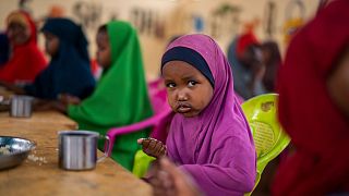 A child eats at a school in Dollow, Somalia, on Sept. 19, 2022. In many Middle Eastern and African nations, climatic shocks kill hundreds and displace thousands every year.