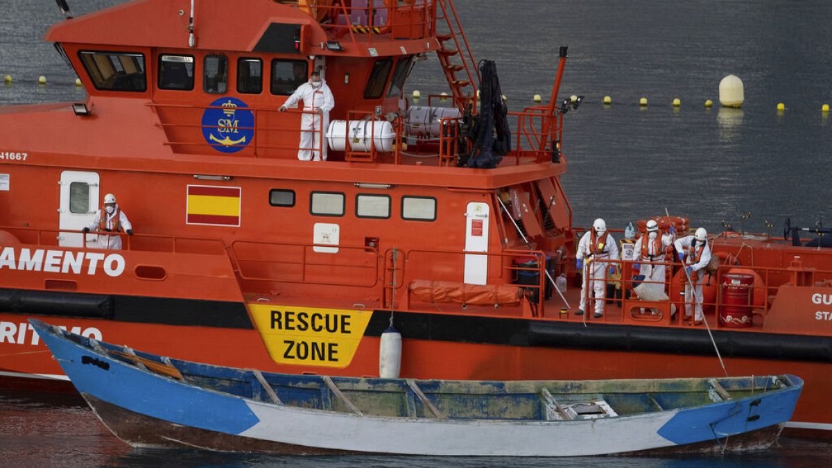 Una embarcación de madera es remolcada por un buque del Servicio de Salvamento Marítimo español a su llegada al puerto de Los Cristianos, en el sur de Tenerife, en la isla canaria, España.