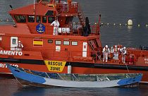 un bateau en bois est remorqué par un navire espagnol du Service de sauvetage maritime à son arrivée au port de Los Cristianos, dans le sud de Tenerife, aux Îles Canaries.