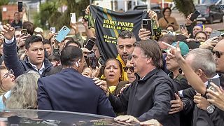 Jair Bolsonaro rodeado de apoiantes