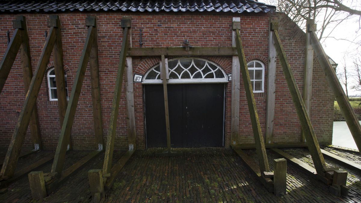 FILE - Support beams stabilize an historic farm in Hunzinge, northern Netherlands, on Jan. 19, 2018. 