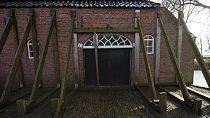 FILE - Support beams stabilize an historic farm in Hunzinge, northern Netherlands, on Jan. 19, 2018.