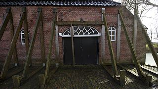 FILE - Support beams stabilize an historic farm in Hunzinge, northern Netherlands, on Jan. 19, 2018. 