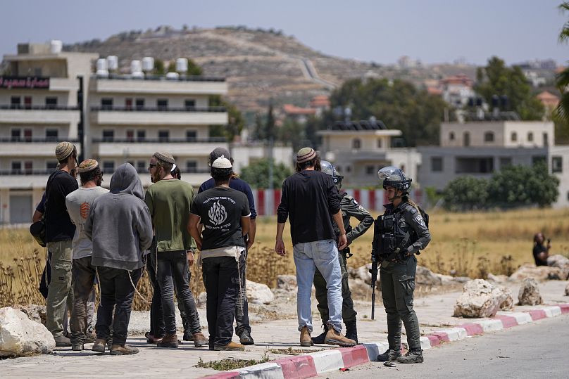 مستوطنون إسرائيليون مع جنود في الضفة الغربية
