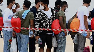 Μετανάστες περιμένουν στην ουρά πριν επιβιβαστούν σε πλοίο στο λιμάνι του νησιού Λαμπεντούζα στις 8 Ιουνίου 2023.