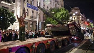 Members of the Wagner Group military company load their tank onto a truck on a street in Rostov-on-Don, Russia, Saturday, June 24.