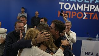 Kyriakos Mitsotakis leader of center-right New Democracy hugs his family at the headquarters of the party in Athens, Greece, Sunday, June 25, 2023.