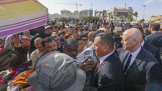 الرئيس التونسي قيس سعيد، على اليمين، يلتقي بالسكان خلال زيارة مفاجئة إلى صفاقس، 10 يونيو 2023.