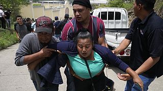 Wähler helfen einer Frau in Guatemala-Stadt, die während der Unruhen am Wahltag Tränengas einatmete