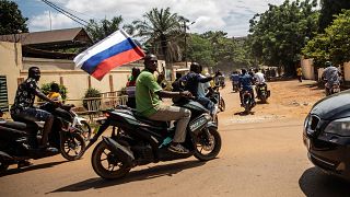 Kormánypárti férfi orosz zászlóval Burkina Faso fővárosában, Ouagadougou-ban